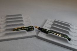 A Conway Stewart Dinkie 560 leverfill fountain pen in green marble with single band to the cap
