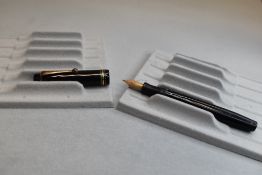 A Parker Duofold button fill fountain pen in black with one braod and two narrow bands to the cap