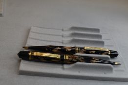 Two propelling pencils in black and gold marbling, octagonal shaped barrel with three gold bands