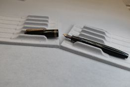 A Parker Victory button fill fountain pen in dark green with two narrow bands to the cap having a