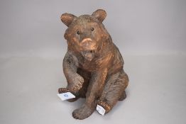 A hand carved black forest bear figure in a seated position