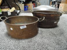 Two antique copper planters having brass handles.