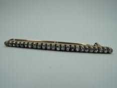 An old cut diamond bar brooch having 24 diamonds, total approx 0.75ct in a yellow metal collared