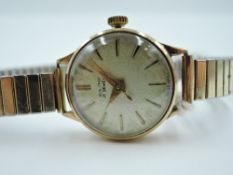 A lady's 9ct gold wrist watch by Baume having baton numeral dial to champagne face in gold case,