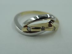 A small 9ct white and yellow gold dress ring having a trio of diamond chips in a stylised setting on