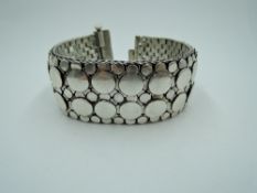 A white metal cuff bracelet stamped 925 of Artisan woven articulated style having circle
