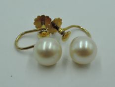 A pair of yellow metal screw back cultured pearl earrings stamped 9ct