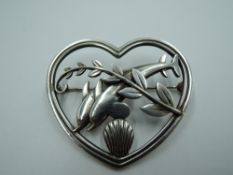 A silver dolphin brooch by Georg Jensen no 312, designed by Arno Molinowski, having a pair of diving