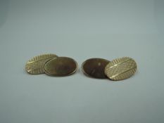 A pair of 9ct gold cufflinks having oval panels, chain connectors and engine turned decoration,