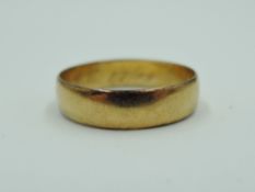An 18ct rose gold wedding band having inscription to inside dated 1909, size O & approx 2.2g