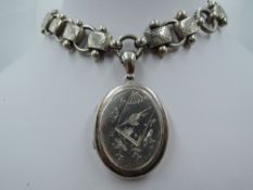 A Victorian silver oval locket having naturalistic engraved decoration to front and monogram en