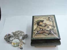 A wooden Hummel musical box containing eight costume brooches