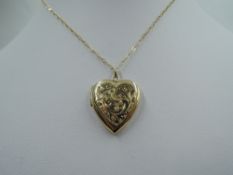 A 9ct gold heart shaped locket having engraved scroll decoration to front on yellow metal chain