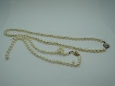 A knotted string of cultured pearls of even form having circular yellow metal box clasp stamped 333,