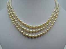 A graduated cultured pearl three string necklace having a diamond set white metal clasp stamped 9ct,