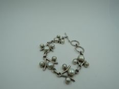 A white metal bracelet stamped 925 of Artisan style having split cultured pearl decoration with