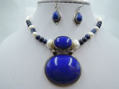 A baroque pearl and lapis lazuli necklace having large pendant drop in white metal mount stamped