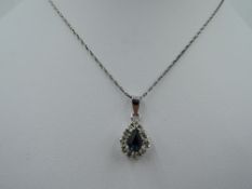 A cubic zirconia and blue paste teardrop cluster in white metal mount stamped 925 on a white metal