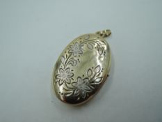 A 9ct gold oval locket having white and yellow gold engraved floral decoration, (no chain) approx