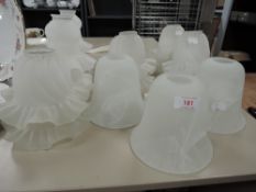 A mixed collection of glass shades some having fluted edges, others of plainer form.