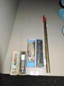 Two vintage harmonicas in boxes and a tin whistle.