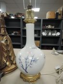 A large oriental style lamp having whit ground with blue cherry blossom pattern.