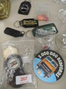 A selection of collectable automobile badges and keyrings including Land rover and Daimler.