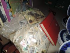 A book of world interest stamps and a bag full of Brooke Bond tea cards and albums.