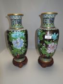 Two large cloisonné vases on wooden stands having decoration of chrysanthemums to black ground.