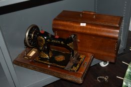 An antique hand cranked sewing machine by Jones with case