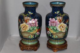 A pair of large Chinese cloisonne vase having deep blue grounds on carved stands