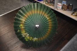 A Chinese parasol having hand painted flower scene