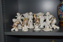 A selection of white glaze porcelain cherubs and similar bird figures some marked Dresdon and