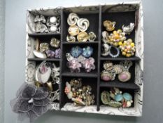 A tray containing a selection of clip earrings and brooches including Monet & Pilgrim