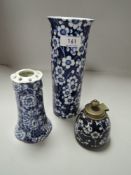 A Frederick Rhead Woods'Prunus' vase, a blue and white hat pin holder and a similar ink well with