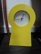 A metal wall clock storage unit in bright yellow