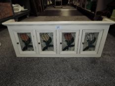 A spice style cabinet having painted glass doors