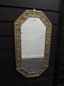 An antique embossed brass frame bevel glass mirror having ivy pattern to frame.