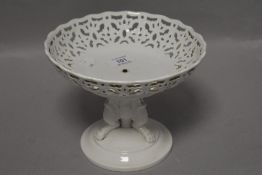 A 19th century porcelain comport having three lions paws to base and repeating pierced pattern to