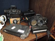 Four vintage cameras including two Polaroids