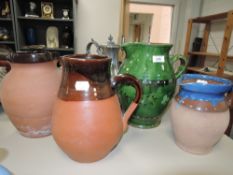 Four earthen ware water jugs or pitchers including green glaze arts and crafts style