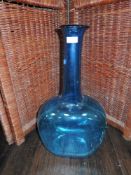 A large blue flat glass vessel having flat faces to front and rear.