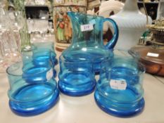 A mid century styled aqua blue glass water jug and glass set