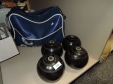 A set of four Thomas Taylor flat green bowls, with blue vinyl carry bag