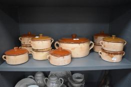 A group of eleven French part-glazed earthernware lidded oven wares, impressed marks 'Aegitna