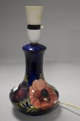 A vintage Moorcroft pottery lamp base having deep blue glaze on anemone