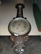 A vintage banjo style aneroid barometer having carved oak frame work