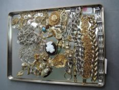 A selection of gold and silver plated costume jewellery including cufflinks, brooches, chains, dress