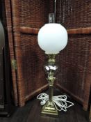 A converted brass Corinthian column table lamp, with clear glass reservoir and milk glass