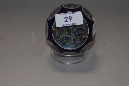 A Perthshire glass close-pack milliefiori paperwight, purple cased with wheel-cut 'windows' re-